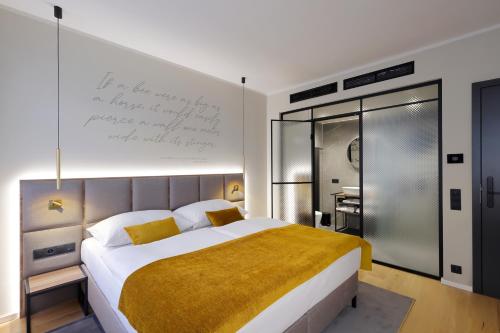 a bedroom with a large bed with a writing on the wall at Hotel Prokop Square in Prague