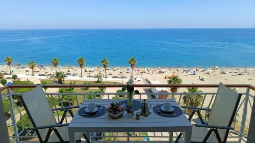 Una mesa en un balcón con vista a la playa. en Maremare, really on the Beach, with private parking, en Savona