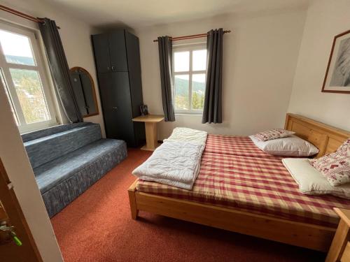a bedroom with two beds and a couch at Astoria Inn in Špindlerův Mlýn