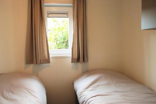 1 dormitorio con cama y ventana en Chalet Merel en Drijber