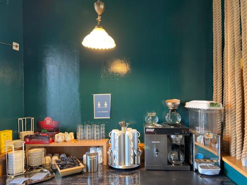 a kitchen with a green wall and a counter with appliances at Hotel Abtshof in Halberstadt