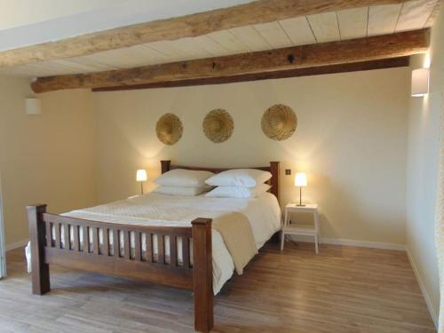 1 dormitorio con 1 cama grande y 2 lámparas en la pared en Mirathe, en Baleyssagues