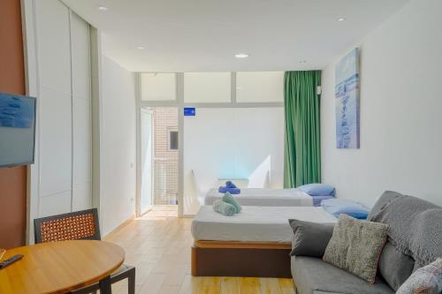 sala de estar con 2 camas y sofá en 404 Apartamento nuevo con vista mar, en Las Palmas de Gran Canaria