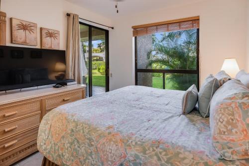 ein Schlafzimmer mit einem Bett und einem großen Fenster in der Unterkunft Shores at Waikoloa #132 condo in Waikoloa