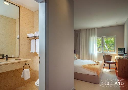 モンシケにあるPure Monchique Hotel - by Unlock Hotelsのベッドとバスルーム付きのホテルルームです。