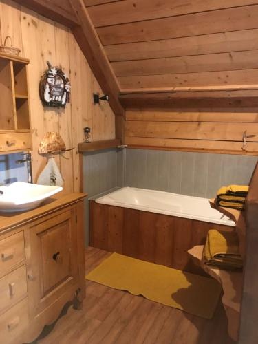 ein Badezimmer mit einer Badewanne und einem Waschbecken in der Unterkunft Chambre d'hôtes Carélie et Laponie in Orbey