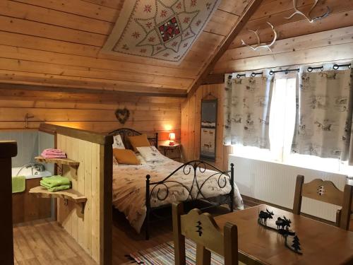 a bedroom with a bed in a wooden cabin at Chambre d'hôtes Carélie et Laponie in Orbey