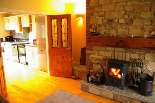 a living room with a stone fireplace in a kitchen at Cosy & convenient beach retreat in Tramore