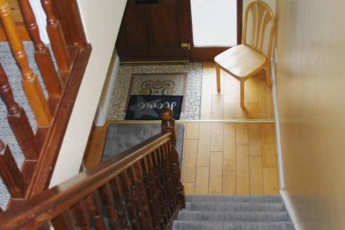 a staircase with a chair and a table in a room at Cosy & convenient beach retreat in Tramore