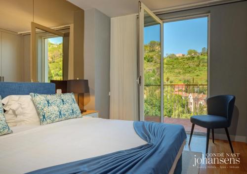 a bedroom with a bed and a chair and a window at Pure Monchique Hotel - by Unlock Hotels in Monchique