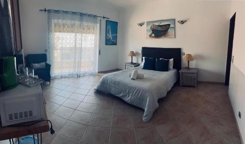 a bedroom with a bed with blue pillows and a window at Lagos Marina Guest House in Lagos