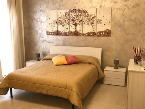 B&B CASA ELISABETTA في جينوسا: غرفة نوم بها سرير و لوحتين على الحائط