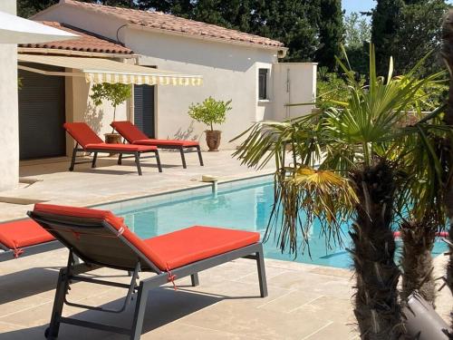 een zwembad met ligstoelen en een zwembad bij Villa Rochefort-du-Gard proche Avignon in Rochefort-du-Gard