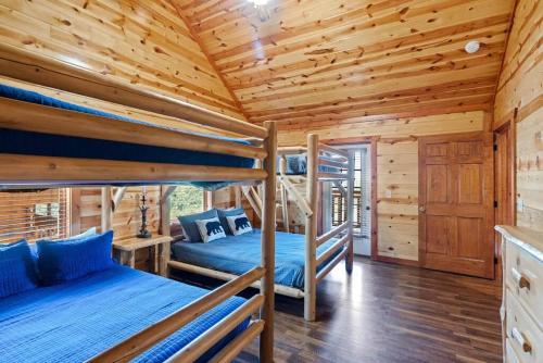 two bunk beds in a log cabin with wooden ceilings at Heated Pool Hot Tub Game Room Mountain Views in Sevierville