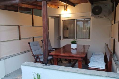 a patio with a wooden table and a chair at Holiday House near Beach in Skala Fourkas