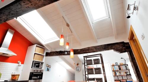 a kitchen with orange walls and white ceilings at Atico con encanto en el mismo centro de la ciudad in Santander