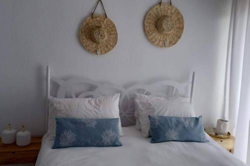 a bedroom with a bed with blue and white pillows at Holiday House near Beach in Skala Fourkas