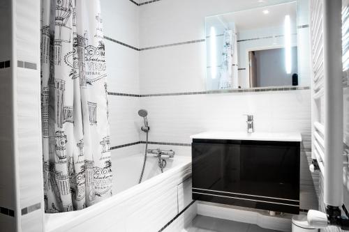 un bagno bianco con tenda doccia e lavandino di Convenient 2BR Apt near subway a Noisy-le-Grand