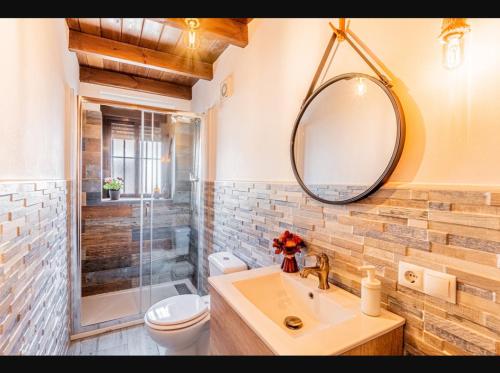 a bathroom with a sink and a shower and a mirror at Fuente Vieja in Cortegana