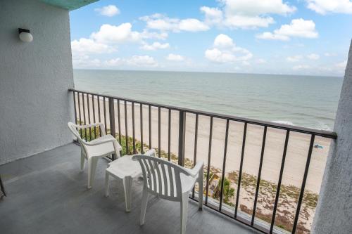 a balcony with two chairs and a view of the beach at Tropical Seas Hotel in Myrtle Beach