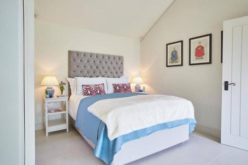 a white bedroom with a large bed and two lamps at The Garden House - Luxurious bolthole near coast in Banningham