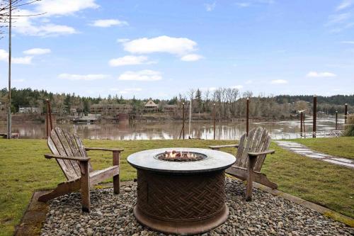a fire pit sitting between two chairs in a yard at River Forest Retreat in Milwaukie