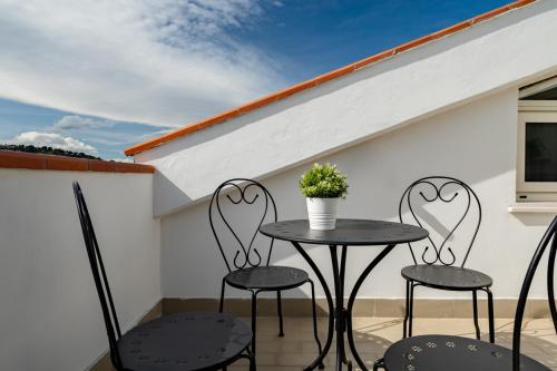 a patio with two chairs and a table with a potted plant at I fiori del mare - YourPlace Abruzzo in Francavilla al Mare