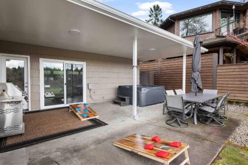 a patio with a grill and a table with a table at River Forest Retreat in Milwaukie