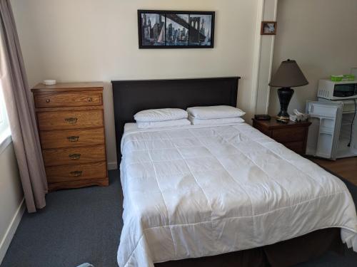 Ein Bett oder Betten in einem Zimmer der Unterkunft Orchard Queen Motel & Rv Park