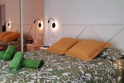 a bed with two green pillows on top of it at Soleado apartamento con garaje in Santander