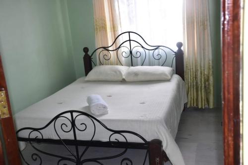 1 dormitorio con 1 cama en blanco y negro y ventana en 3-bedroom, 2-bedroom, 1-bedroom serenity homes en Langata Rongai