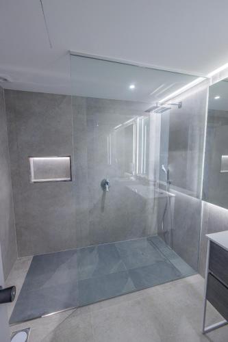 a shower with a glass door in a bathroom at Sea Breeze III in Caniço