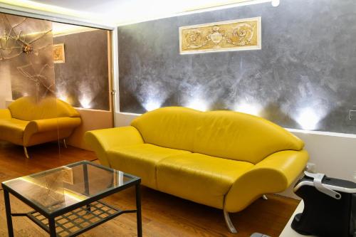 a living room with a yellow couch and a table at Avanguardia Art Club in Ferrara