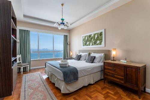 een slaapkamer met een bed en een groot raam bij Sofisticado em Copacabana - 2 Suites - A801 in Rio de Janeiro