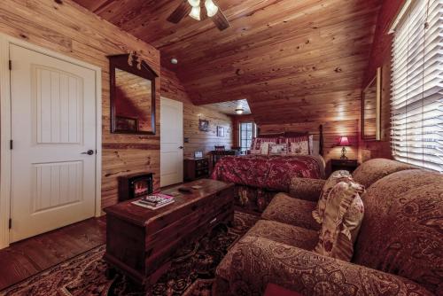 a living room with a couch and a bed in a cabin at Suite Lookout At The Mentone Mountain View Inn in Mentone