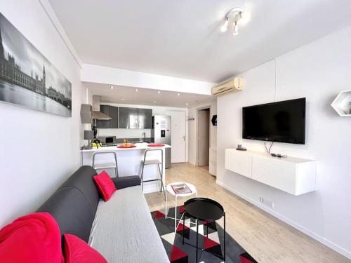 un salon avec un canapé et une cuisine dans l'établissement Le Festival, T2 proche croisette, à Cannes