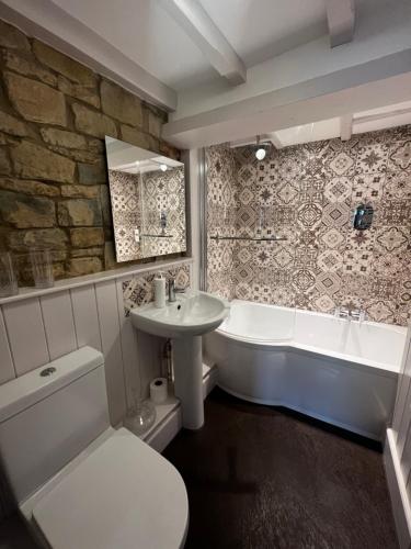 a bathroom with a sink and a tub and a toilet at The Lion, Tredington in Shipston on Stour