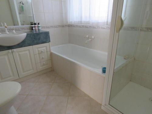 a bathroom with a bath tub and a sink at Beach Cottage in Ventnor in Ventnor