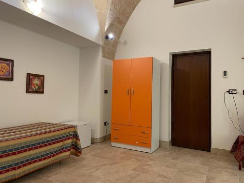 a bedroom with a bed and a orange cabinet at La stella salentina in Montesano Salentino