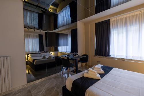 a hotel room with two beds and a dining room at Maximum Exclusive Suite & Spa in Palermo