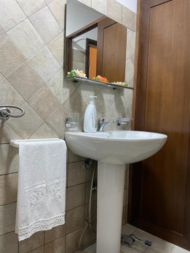 Montesano SalentinoにあるLa stella salentinaのバスルーム(白い洗面台、鏡付)