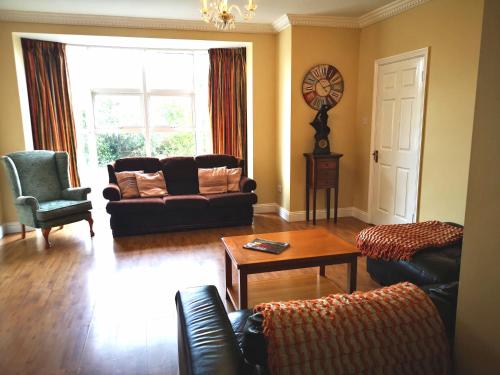 a living room with a couch and a table at Ashton Beach House in Tramore