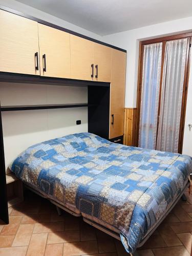 a bedroom with a bed with a blue comforter at Aria Fresca in Sovere