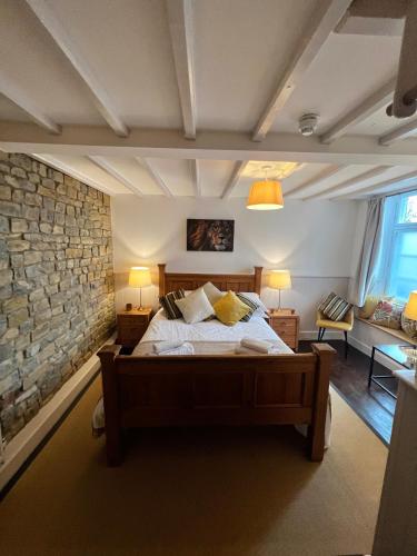 a bedroom with a bed and a stone wall at The Lion, Tredington in Shipston on Stour