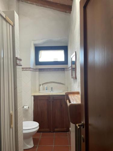 a bathroom with a toilet and a sink and a window at Torre Di Ponzano in Barberino di Val dʼElsa