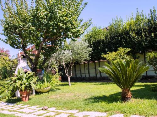 un jardín con árboles y plantas frente a un edificio en A casa tua Ostia Antica en Ostia Antica