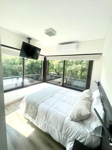 ein Schlafzimmer mit einem großen Bett und einem großen Fenster in der Unterkunft Golf Tower Suites & Apartments in Buenos Aires