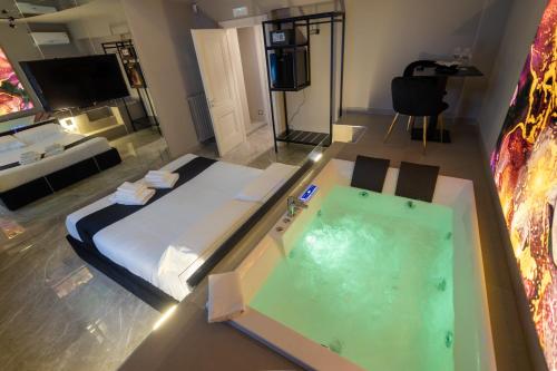 a room with a bed and a jacuzzi tub at Maximum Exclusive Suite & Spa in Palermo