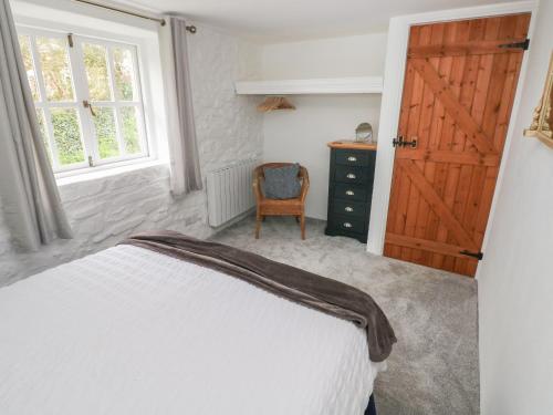 a bedroom with a bed and a wooden door at Sands Cottage in Haverfordwest