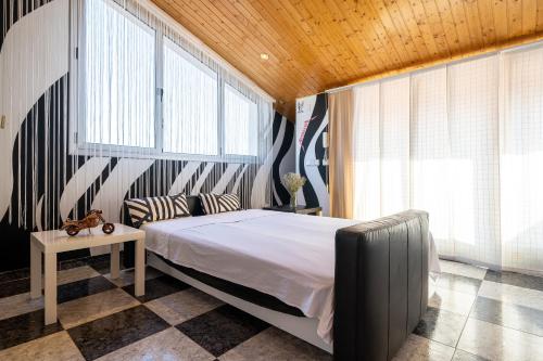 een slaapkamer met een bed, een bank en ramen bij Villa Luxury Rock Tirri in Reus